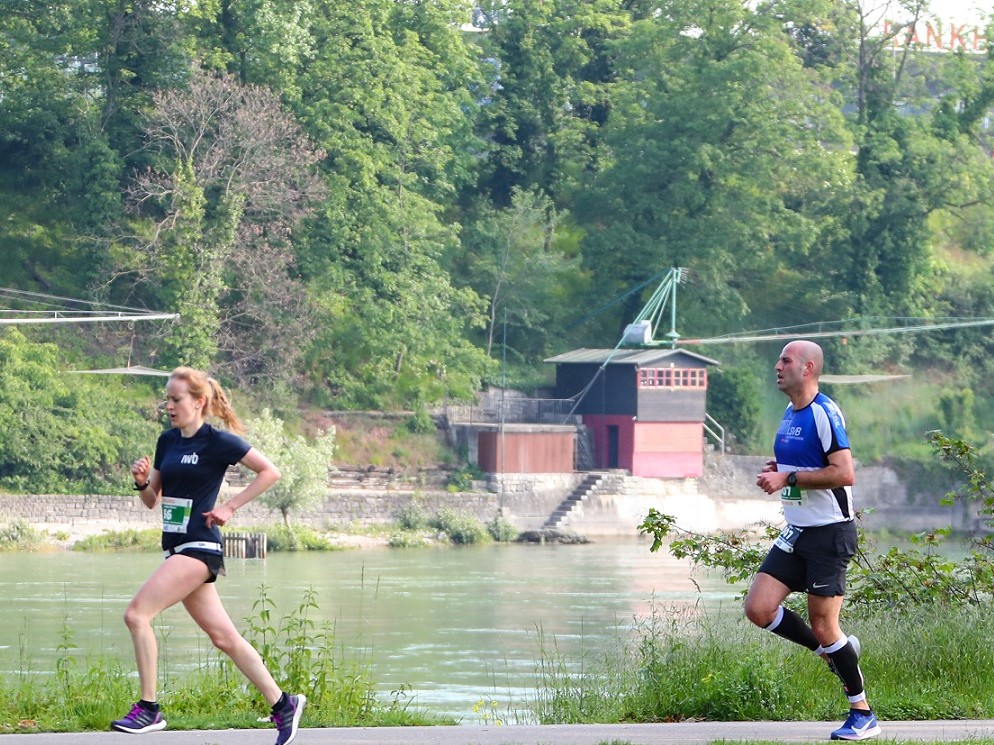Eine Läuferin und ein Läufer laufen an der SOLA 2019 am Fluss entlang